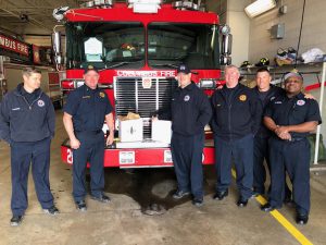 Group of Columbus Firemen in front of their truck with boxes of donated meal delivery from Cooper’s Hawk at Easton.